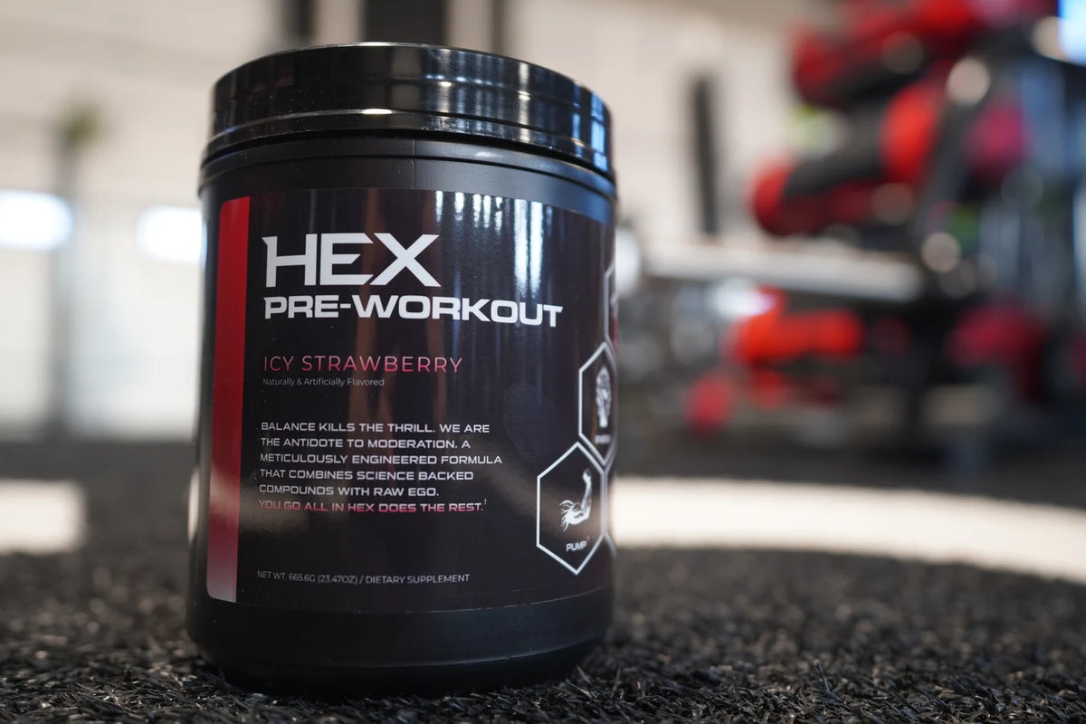 HEX Icy Strawberry pre-workout beside the dumbbell rack.
